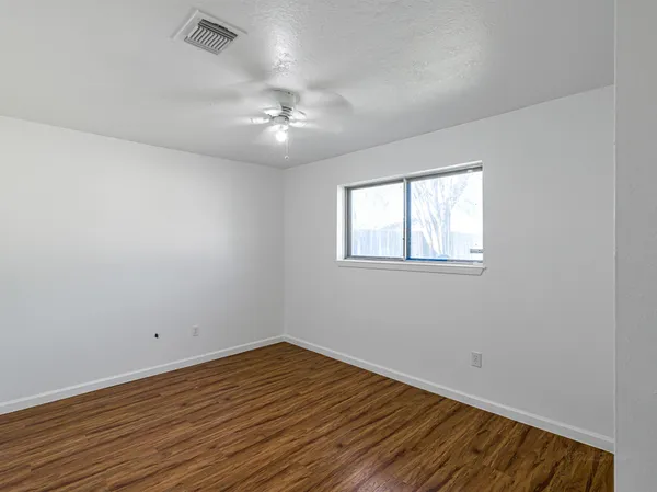 wooden floor in an empty room with a window