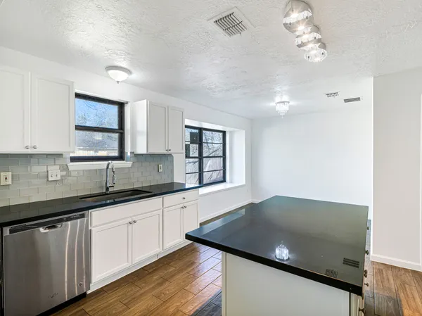 a kitchen with granite countertop a sink cabinets and window