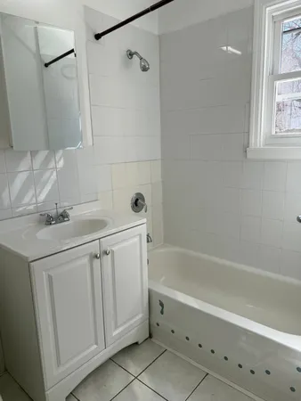 a bathroom with a sink vanity tub and shower