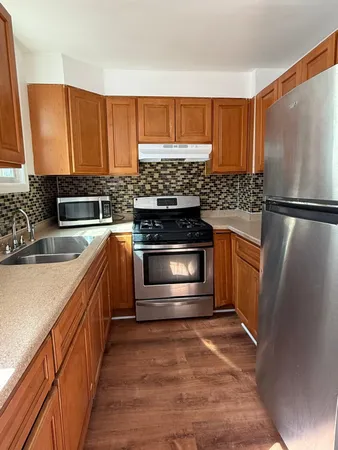a kitchen with stainless steel appliances granite countertop a stove a refrigerator and a sink
