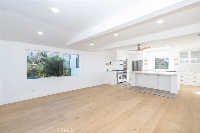 a view of an empty room with a fireplace and a window