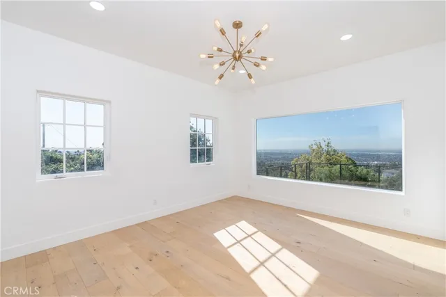 a view of a big room with a chandelier fan and bathroom