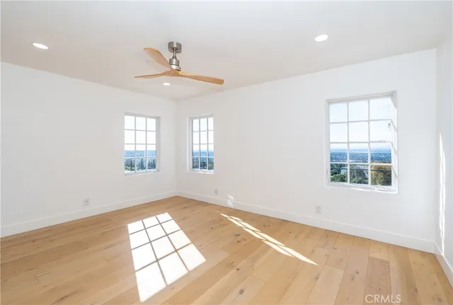 a view of a big room with wooden floor and windows