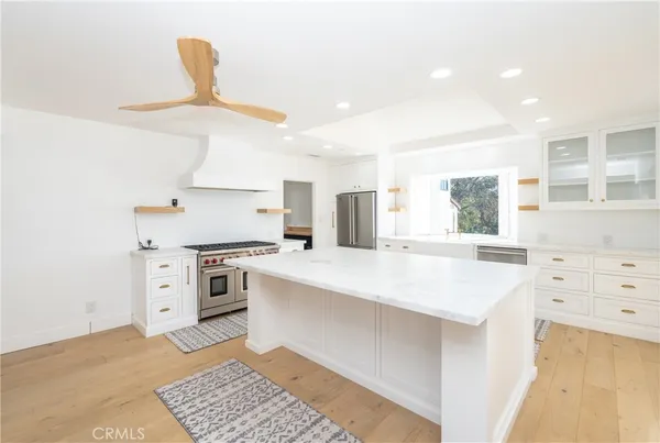 a kitchen with a sink stainless steel appliances a counter top space and cabinets
