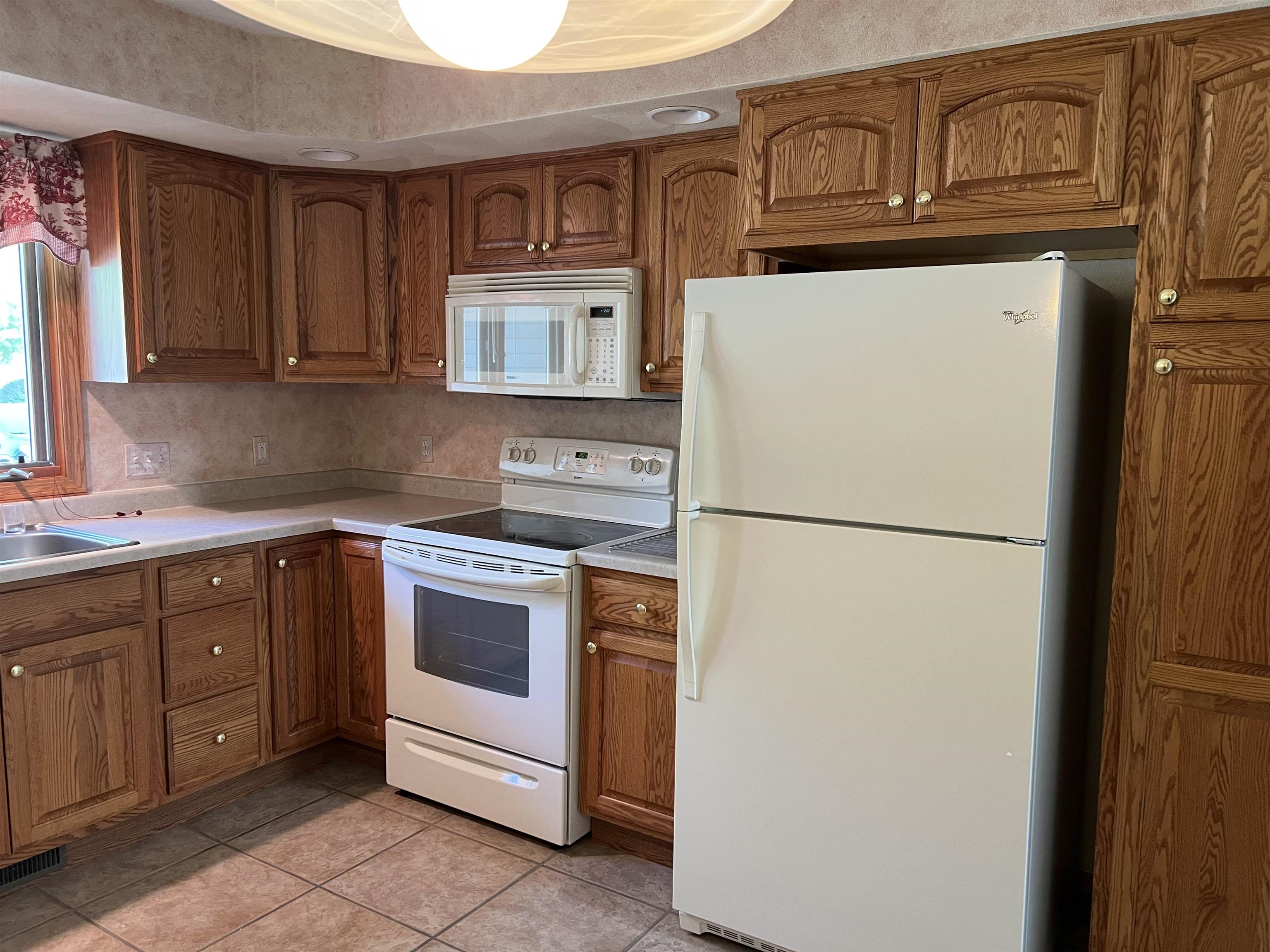 1917 Comanche Court Freeport, IL 61032 - Photo 7 of 25 a white refrigerator freezer sitting inside of a kitchen with stainless steel appliances granite countertop cabinets and a refrigerator