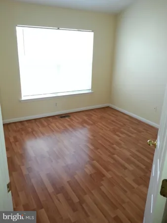 an empty room with wooden floor and closet