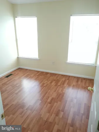 an empty room with wooden floor and closet