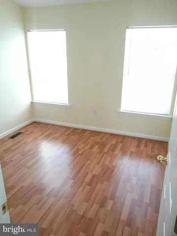 an empty room with wooden floor and closet