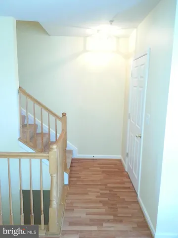 a view of a hallway with wooden floor and entryway