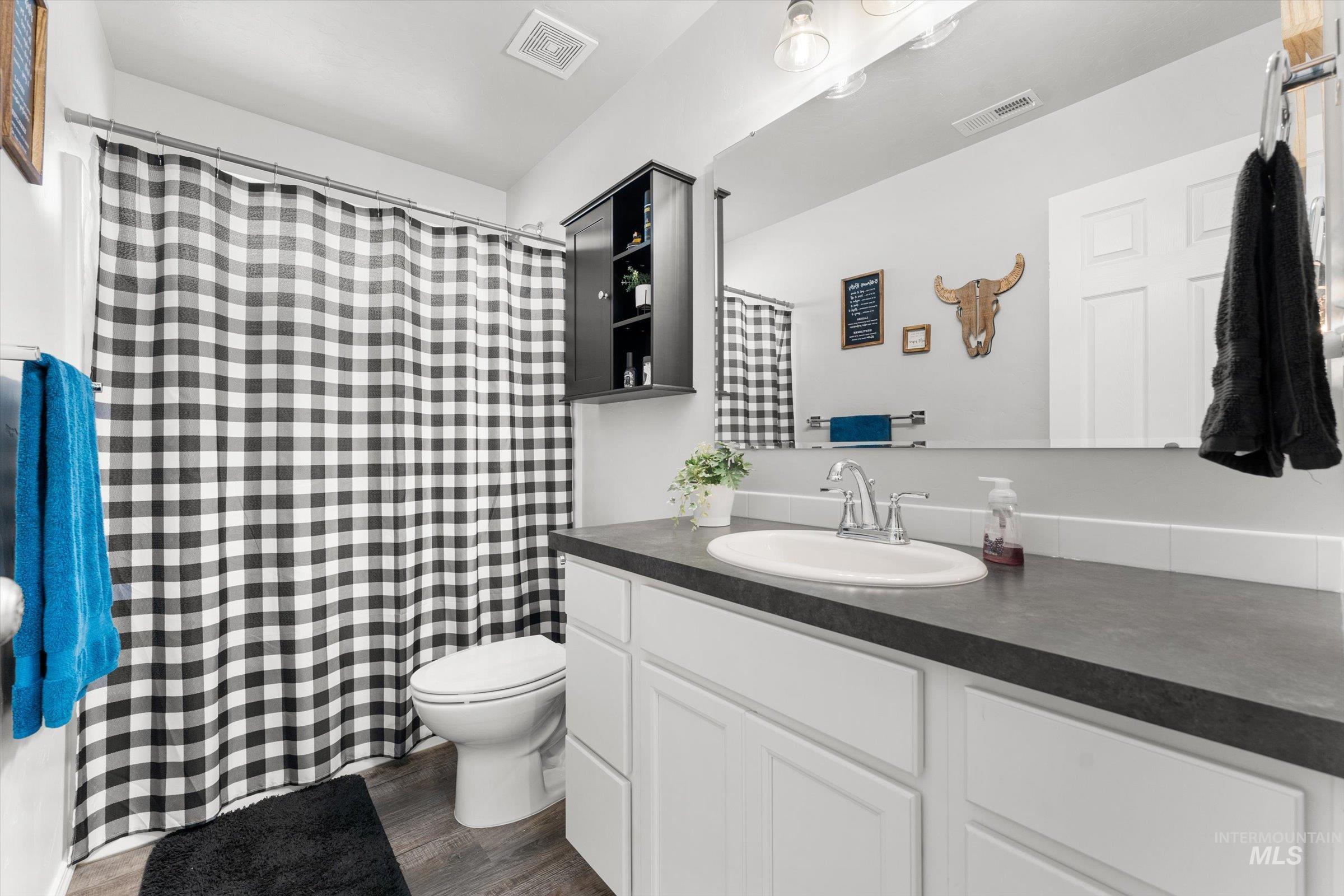 12798 Devonshire Street Caldwell, ID 83607 - Photo 19 of 42 Full bath featuring vanity, curtained shower, and dark wood-type flooring