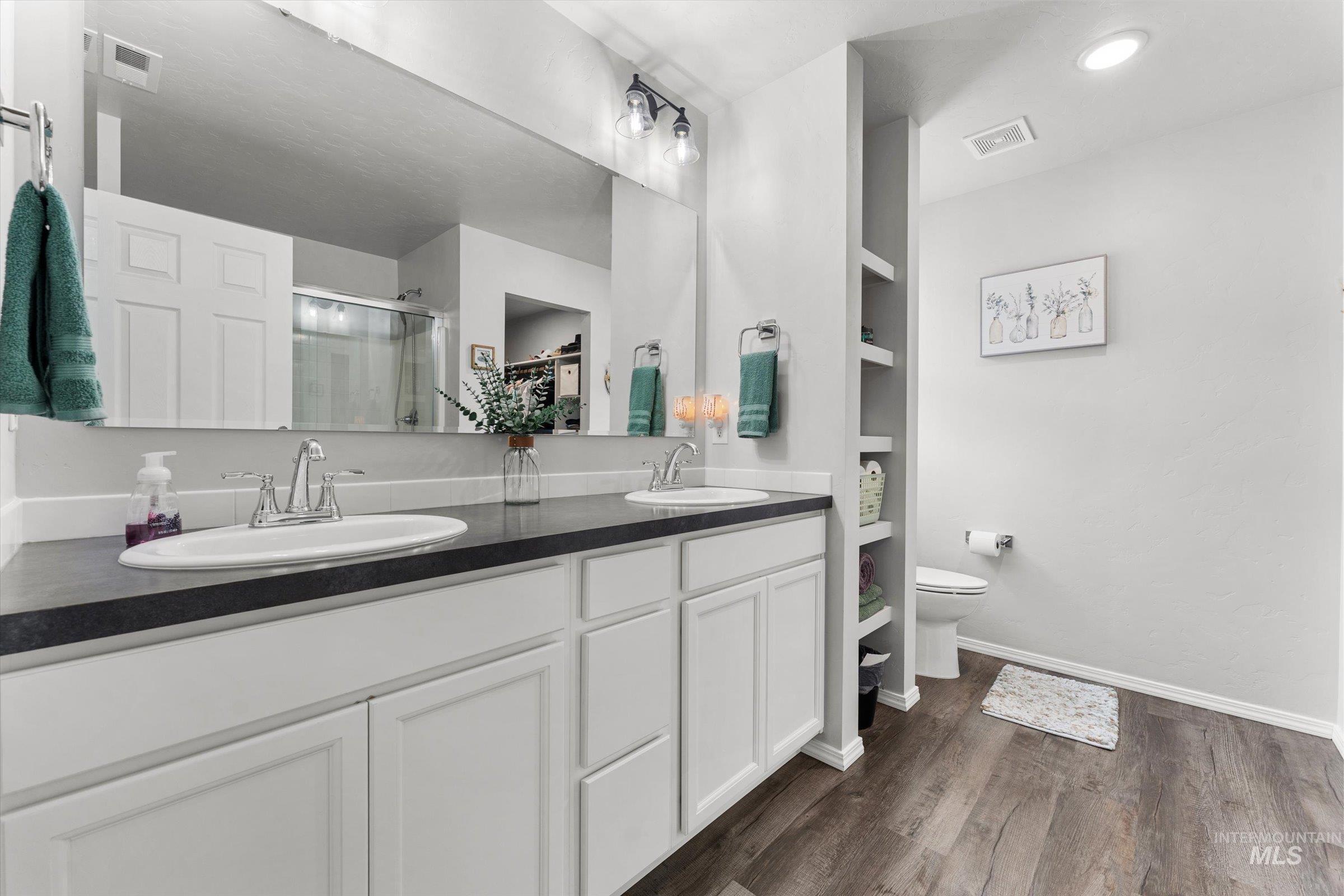 12798 Devonshire Street Caldwell, ID 83607 - Photo 28 of 42 Bathroom with double vanity, a shower stall, dark wood-type flooring, built in features, and recessed lighting