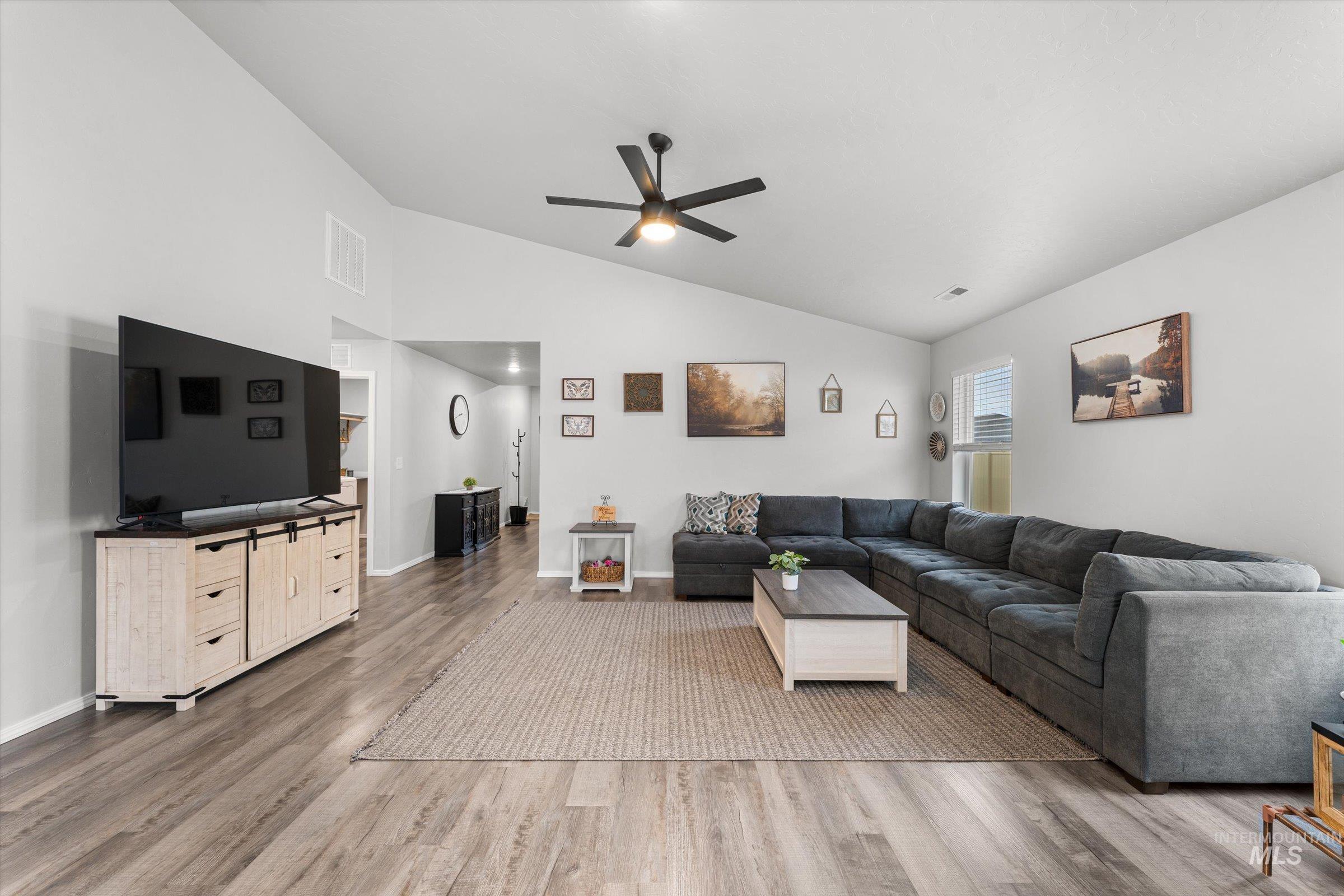 12798 Devonshire Street Caldwell, ID 83607 - Photo 10 of 42 Living room with ceiling fan, light wood-style floors, and vaulted ceiling