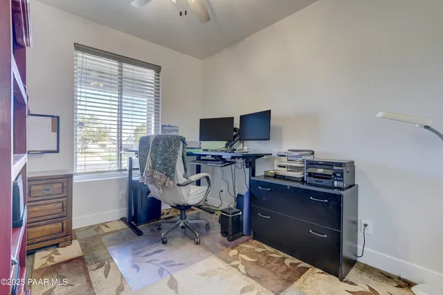 a view of a workspace with furniture and a window