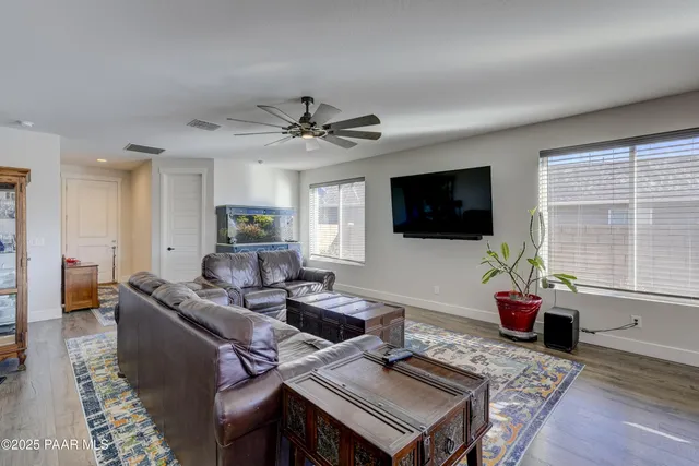 a living room with furniture a flat screen tv and a large window