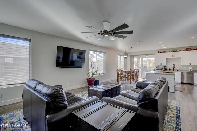 a living room with furniture kitchen view and a flat screen tv