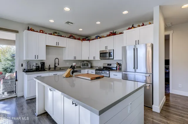 a kitchen with white cabinets and stainless steel appliances
