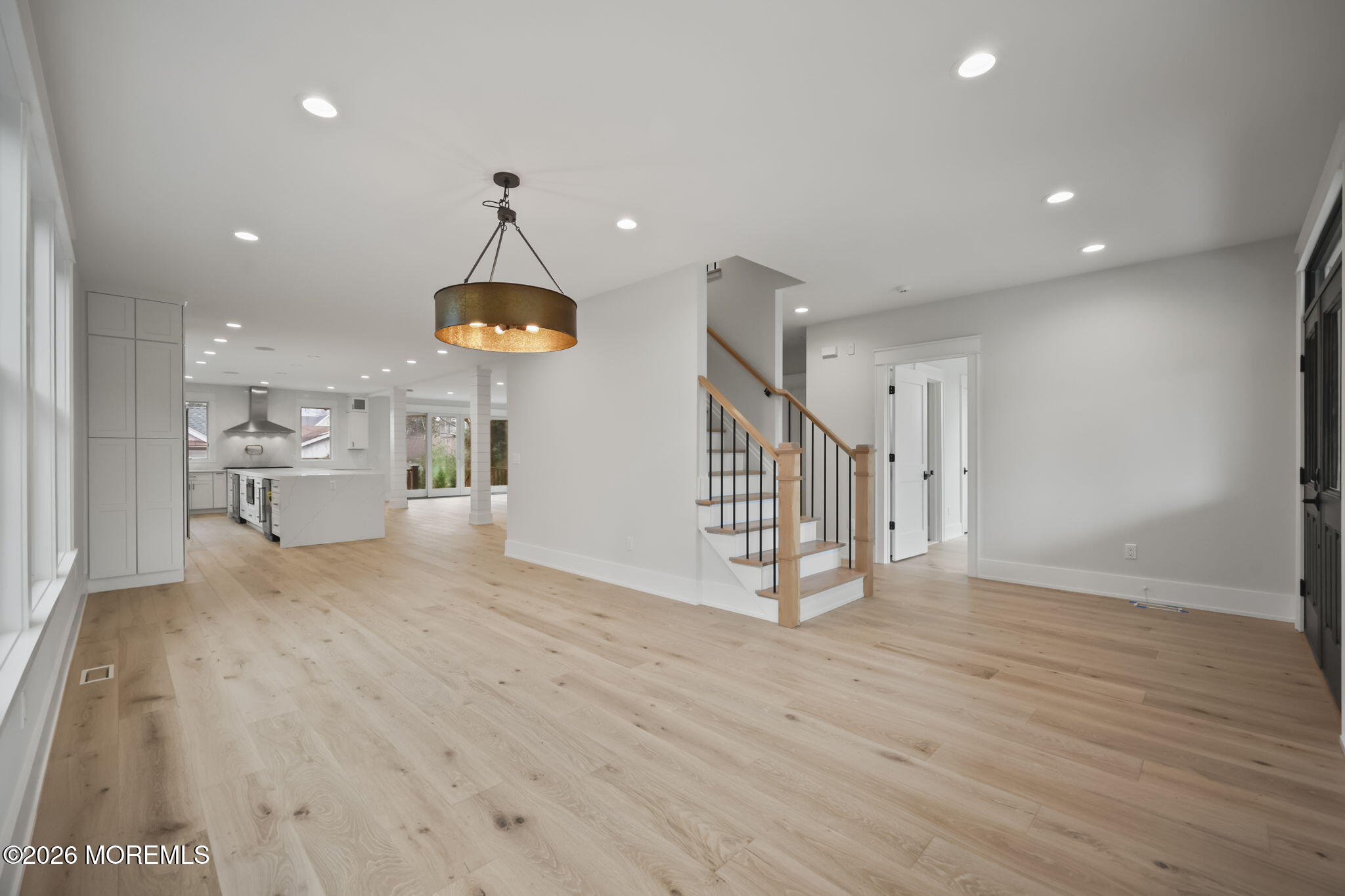 217 Pitney Avenue Spring Lake, NJ 07762 - Photo 6 of 18 a view of a hallway with wooden floor and a chandelier
