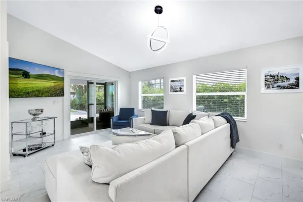 a living room with furniture large window and a flat screen tv