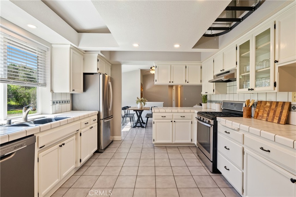 6446 Windmill Place Paso Robles, CA 93446 - Photo 12 of 44 a kitchen with white cabinets and appliances
