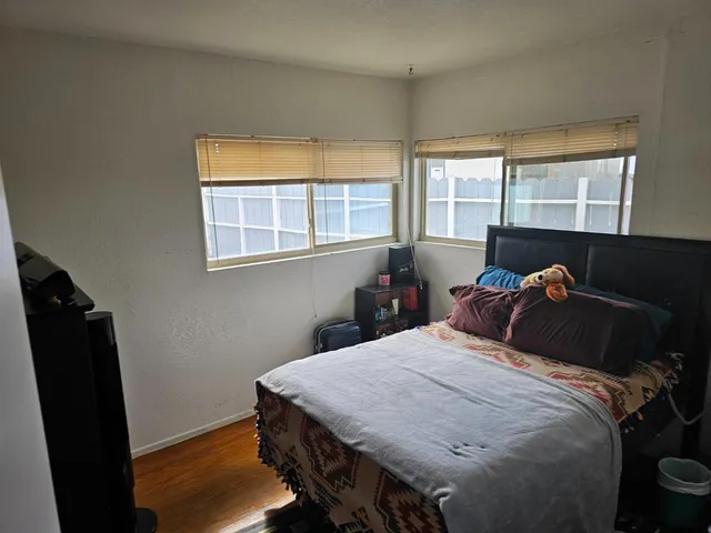 a bedroom with a bed and wooden floor