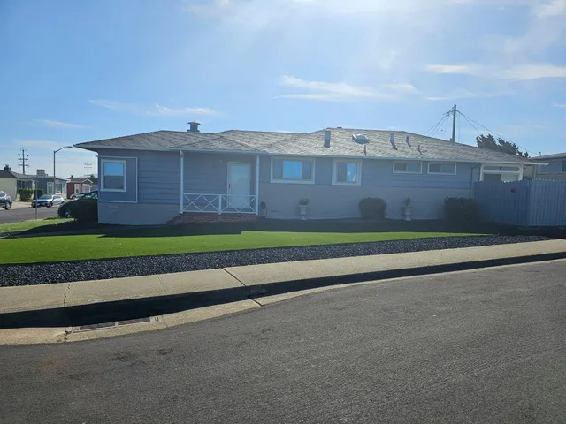 a view of a big house with a big yard and large trees