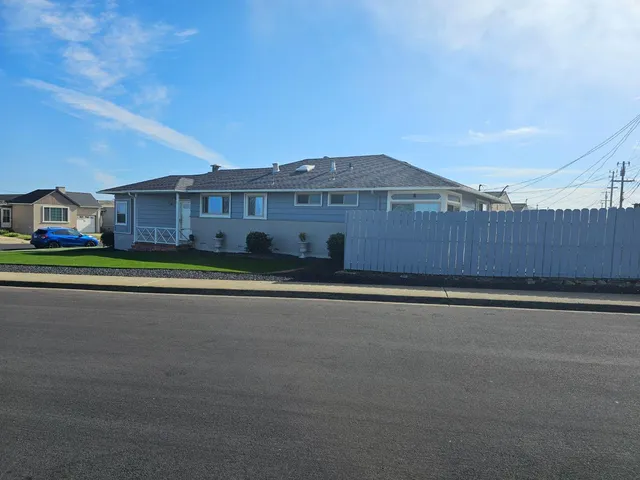 a front view of a house with a yard and road