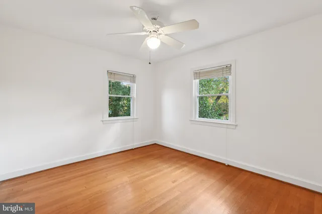 an empty room with a window and a ceiling fan