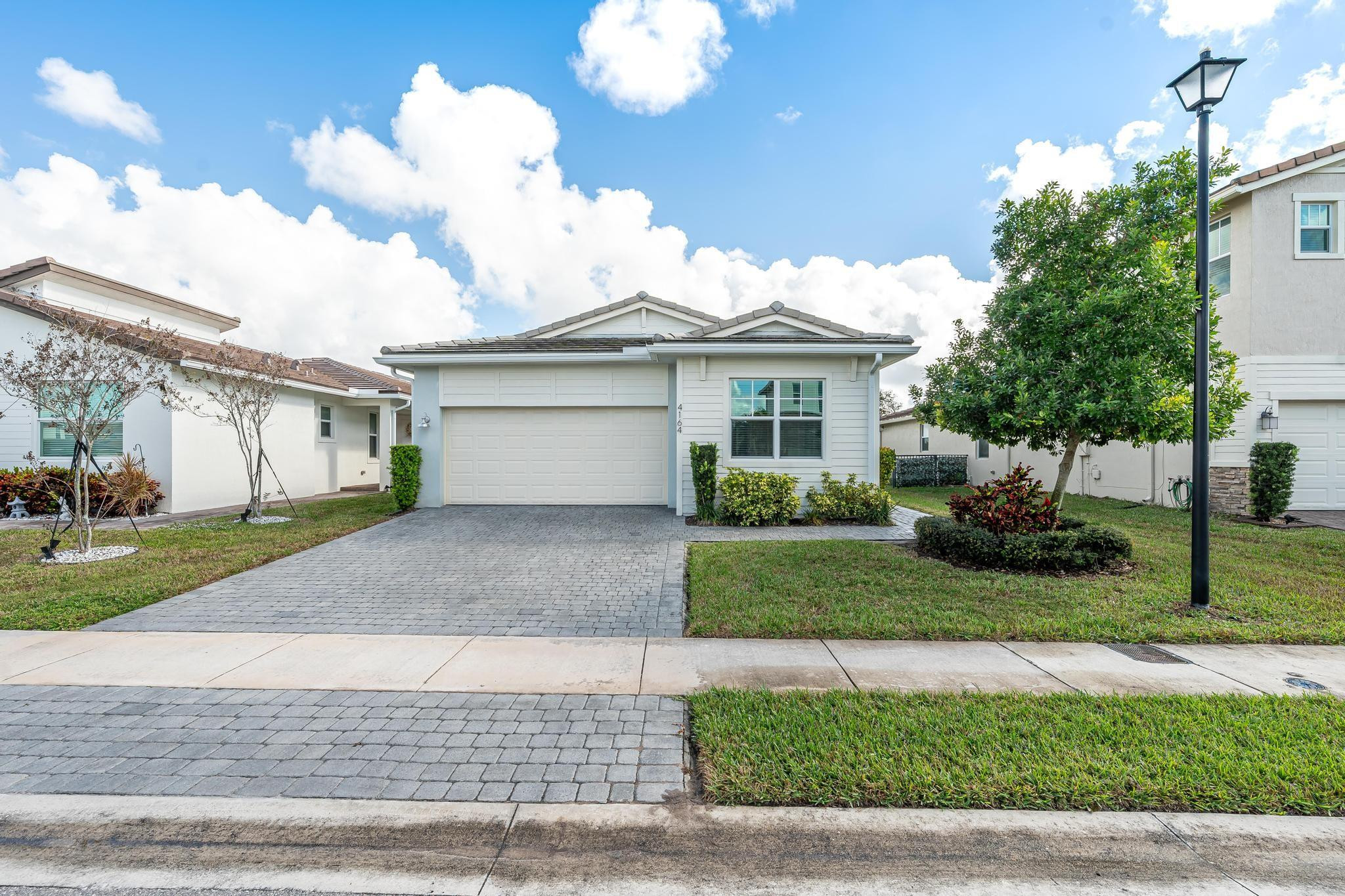 4164 Rosa Drive Deerfield Beach, FL 33064 - Photo 12 of 50 a front view of a house with a yard and a garage