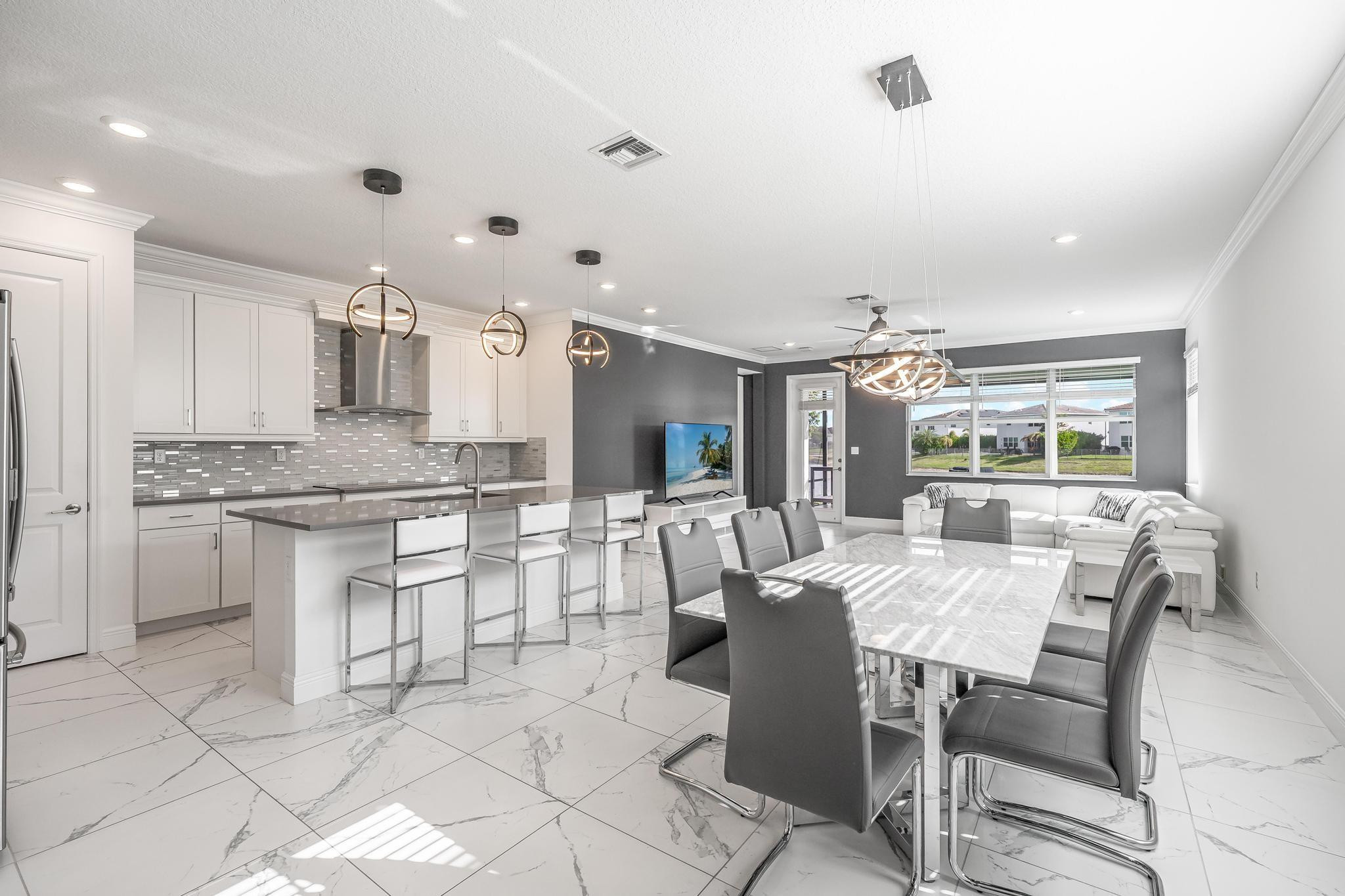 4164 Rosa Drive Deerfield Beach, FL 33064 - Photo 14 of 50 a large kitchen with kitchen island a dining table and chairs
