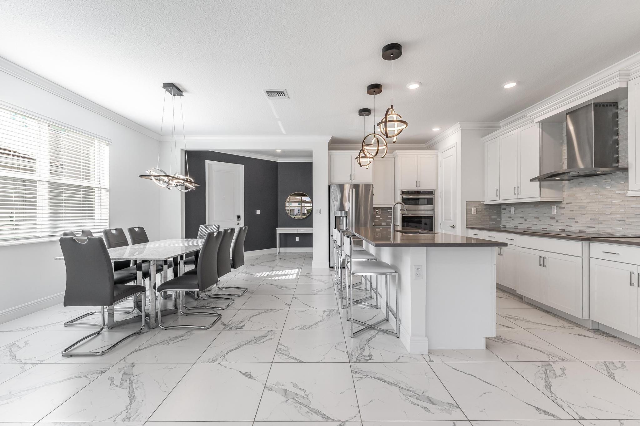 4164 Rosa Drive Deerfield Beach, FL 33064 - Photo 16 of 50 a dining room with stainless steel appliances kitchen island granite countertop a table and chairs