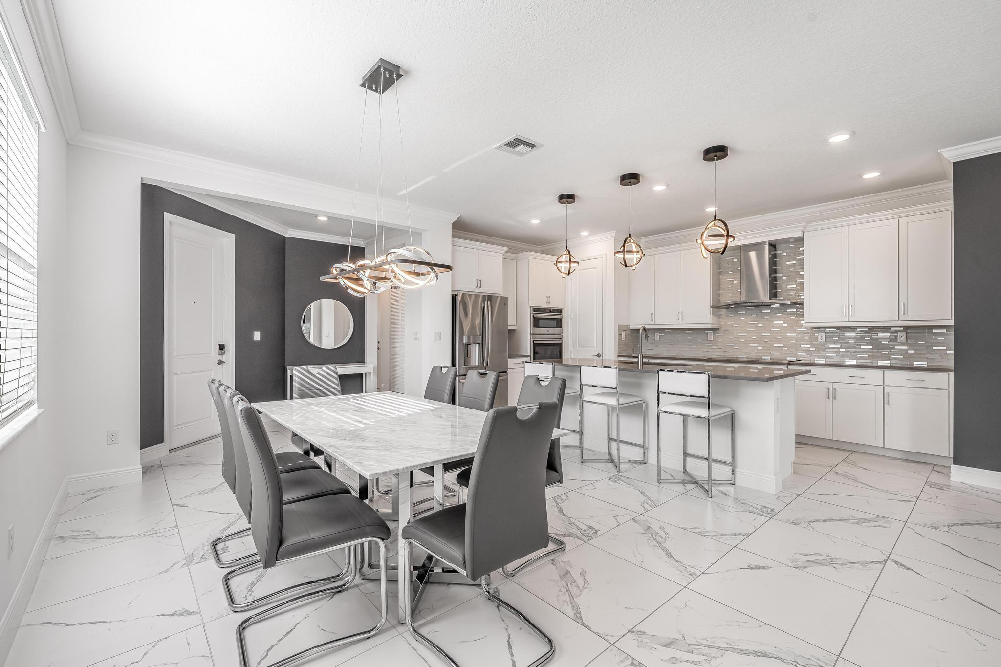 4164 Rosa Drive Deerfield Beach, FL 33064 - Photo 18 of 50 a kitchen with stainless steel appliances kitchen island granite countertop a table chairs and a refrigerator