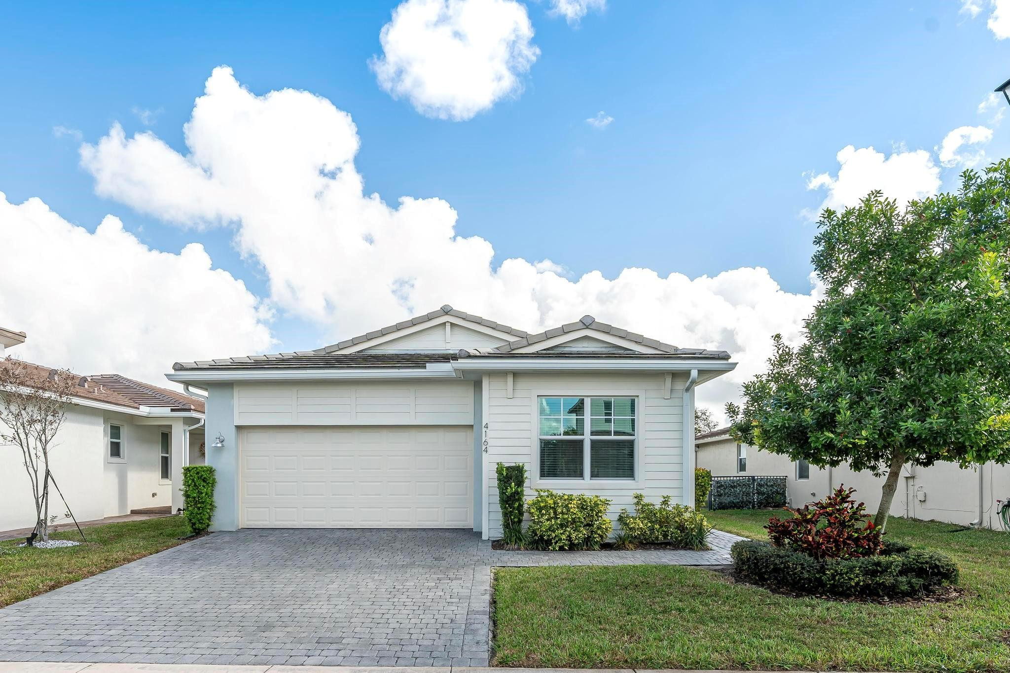 4164 Rosa Drive Deerfield Beach, FL 33064 - Photo 2 of 50 a front view of a house with a garden and plants