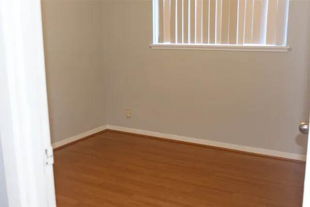 a view of a small space with wooden floor and a window