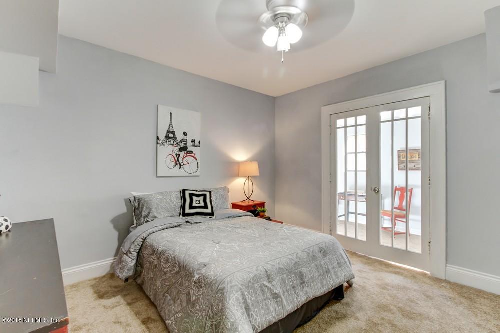 2241 Bayview Road Jacksonville, FL 32210 - Photo 24 of 55 a bedroom with a large bed and a chandelier