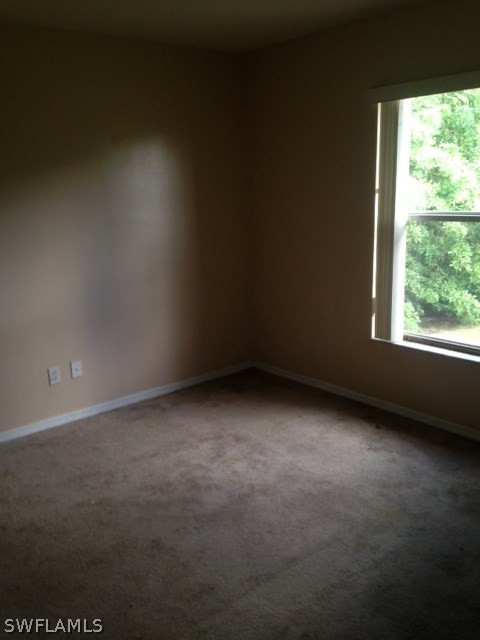 554 Alabama Road South Lehigh Acres, FL 33974 - Photo 3 of 7 a view of an empty room with a window