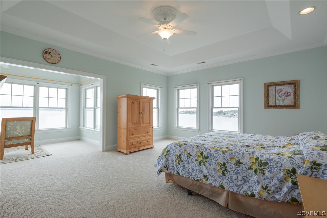 580 Riverside Drive Lancaster, VA 22503 - Photo 39 of 50 a bedroom with a large bed and a chandelier