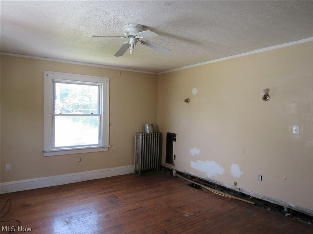 1726 Lee Road Cleveland Heights, OH 44118 - Photo 19 of 36 Room featuring wood-finish flooring, a double-hung window, a ceiling fan, and baseboard trim