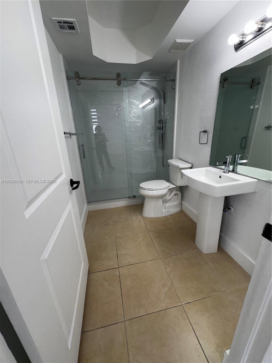 2301 Southwest 27th Avenue, Unit 503 Miami, FL 33145 - Photo 11 of 24 a bathroom with a sink a toilet and shower