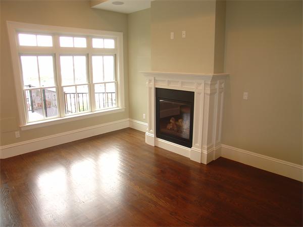 74 F Street, Unit 1 Boston, MA 02127 - Photo 12 of 17 an empty room with wooden floor fireplace and windows