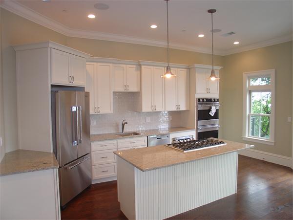 74 F Street, Unit 1 Boston, MA 02127 - Photo 9 of 17 a kitchen with stainless steel appliances granite countertop a refrigerator a sink dishwasher a stove and white cabinets with wooden floor