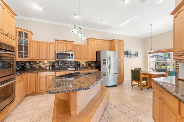 a large kitchen with a large counter top appliances and cabinets