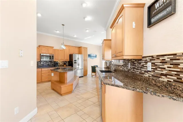 a kitchen with stainless steel appliances granite countertop a sink a stove and a refrigerator