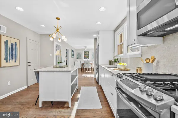 a kitchen with stainless steel appliances granite countertop a stove a sink dishwasher and cabinets with wooden floor