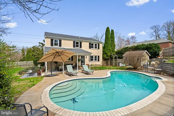 a view of a house with swimming pool and sitting area