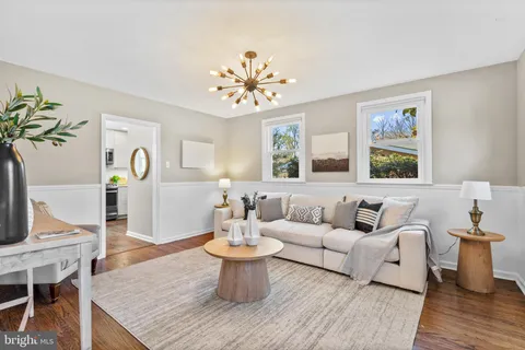 a living room with furniture a chandelier and a table