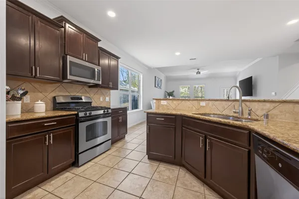 a kitchen with stainless steel appliances granite countertop a sink and stove top oven