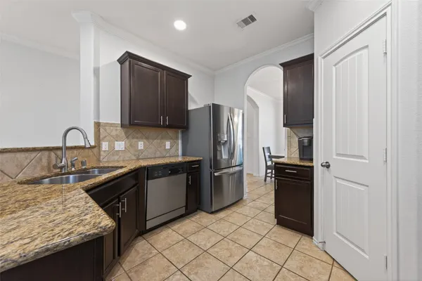 a kitchen with granite countertop a refrigerator stove and sink
