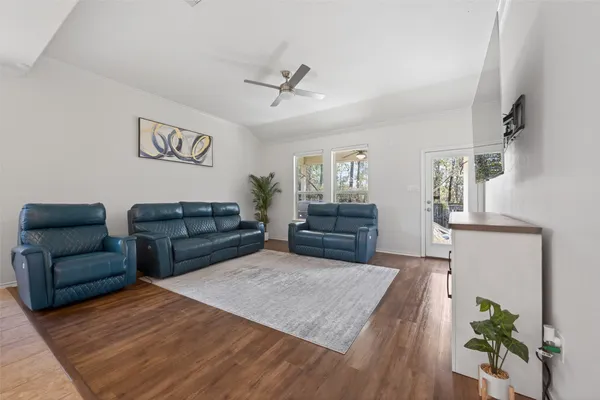 a living room with furniture and a wooden floor