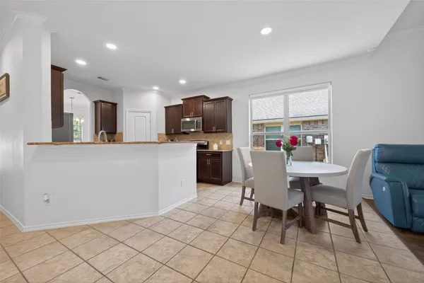 a view of kitchen with stainless steel appliances granite countertop a stove a sink a dining table and chairs