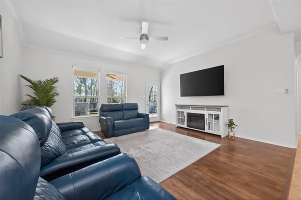 a living room with furniture and a wooden floor